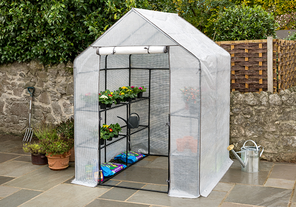 Garden patio with a walk-in greenhouse erected on it.